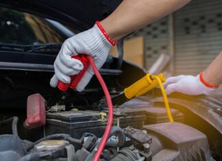 Ładowanie akumulatora w samochodzie. Praktyczne porady Mężczyzna podłącza akumulator samochodowy do ładowania